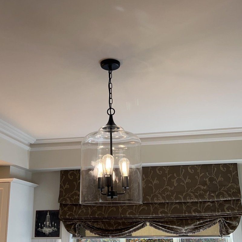 Glass lantern pendant light with candle-style bulbs in a dining room