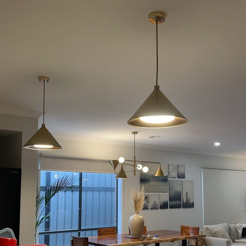 Kitchen and dining area with brass cone pendants and a modern chandelier