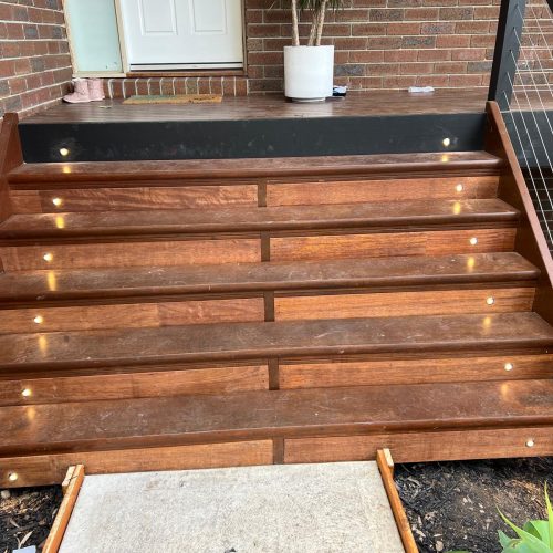 Timber front steps with small step lights leading up to a front door