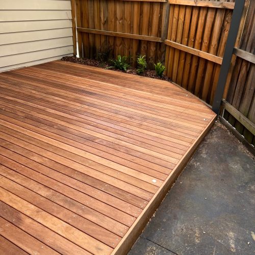 New timber deck beside a fence with small lights set into the boards
